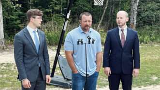 Josh Highlander holds a press conference on his property, flanked by I.J. attorneys Joshua Windham and Joe Gay.