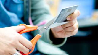 A woman cuts up a credit card