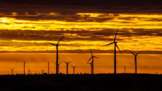 Wind energy turbines are seen at sunrise