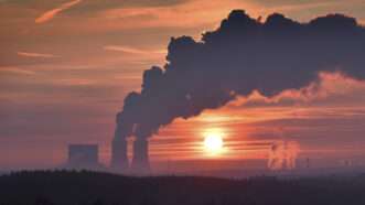 A sunset, depicting the outline of the billowing smokestacks of a coal-fired power plant just south of Liepzig, Germany.