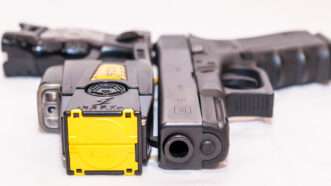 A Taser and a Glock 9mm placed side-by-side.