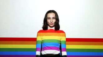 young woman in rainbow flag sweater