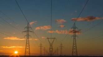Electric transmission lines in front of a sunset