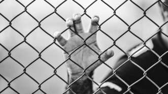 man behind prison fence
