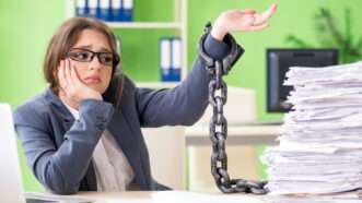 Woman chained to paperwork at her desk