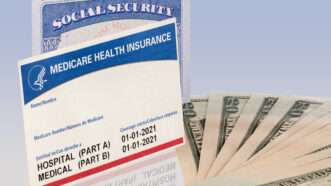 A Social Security card and a Medicare Card and seen next to  bills