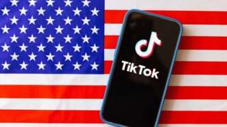 TikTok app on phone in front of American flag